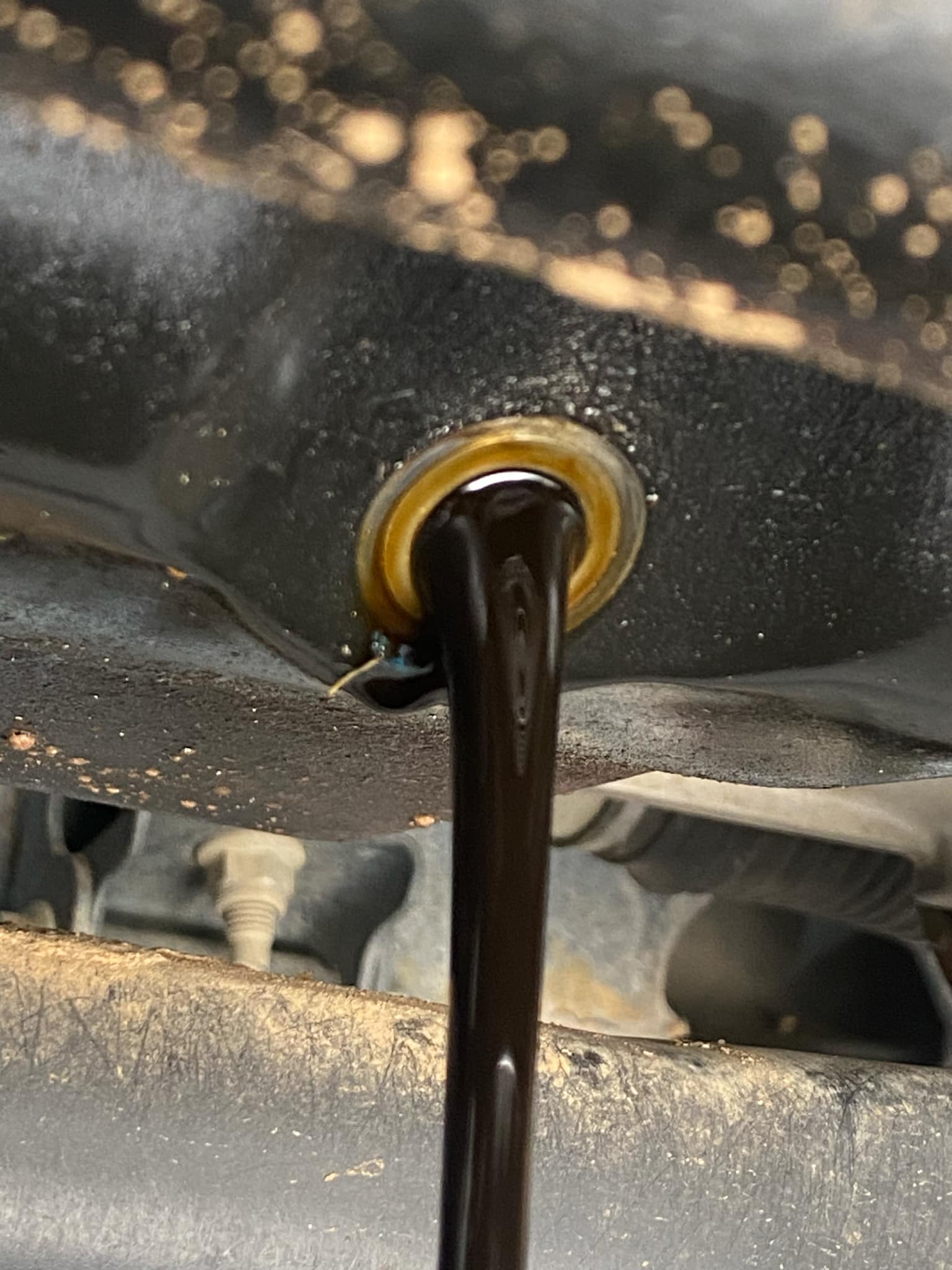 Oil pouring out of the bottom of a car